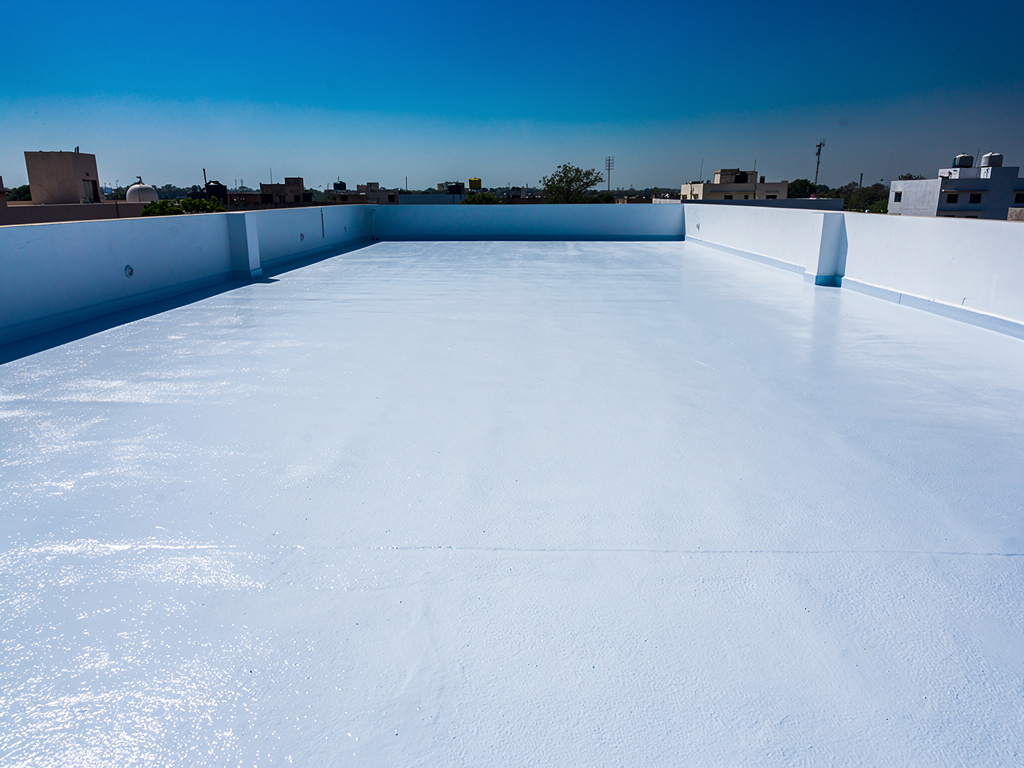 Flat rooftop terrace finished with reflective cool-roof coating under strong sun